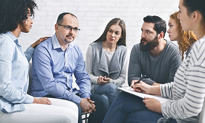 a group of people discuss a mental health treatment center in co
