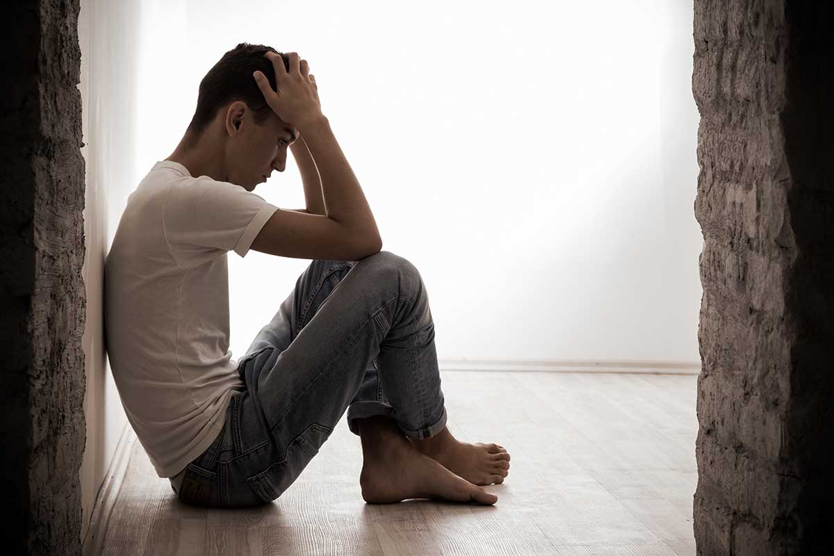 a man sits on a wall at a heroin rehab center in westminster and considers his progress at the heroin addiction treatment program in westminster colorado