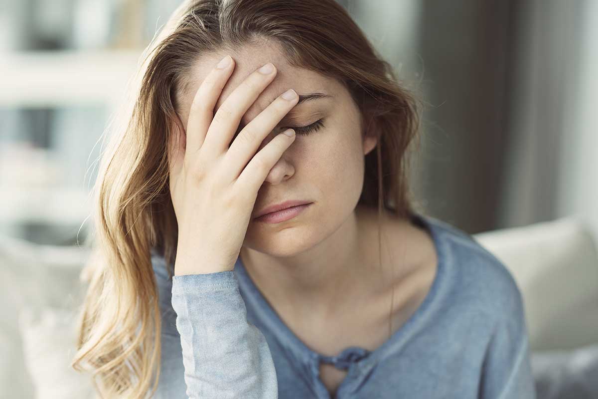 a woman suffering from the effects of opioid addiction considers opioid addiction treatment centers and the benefits of attending an opioid addiction rehab