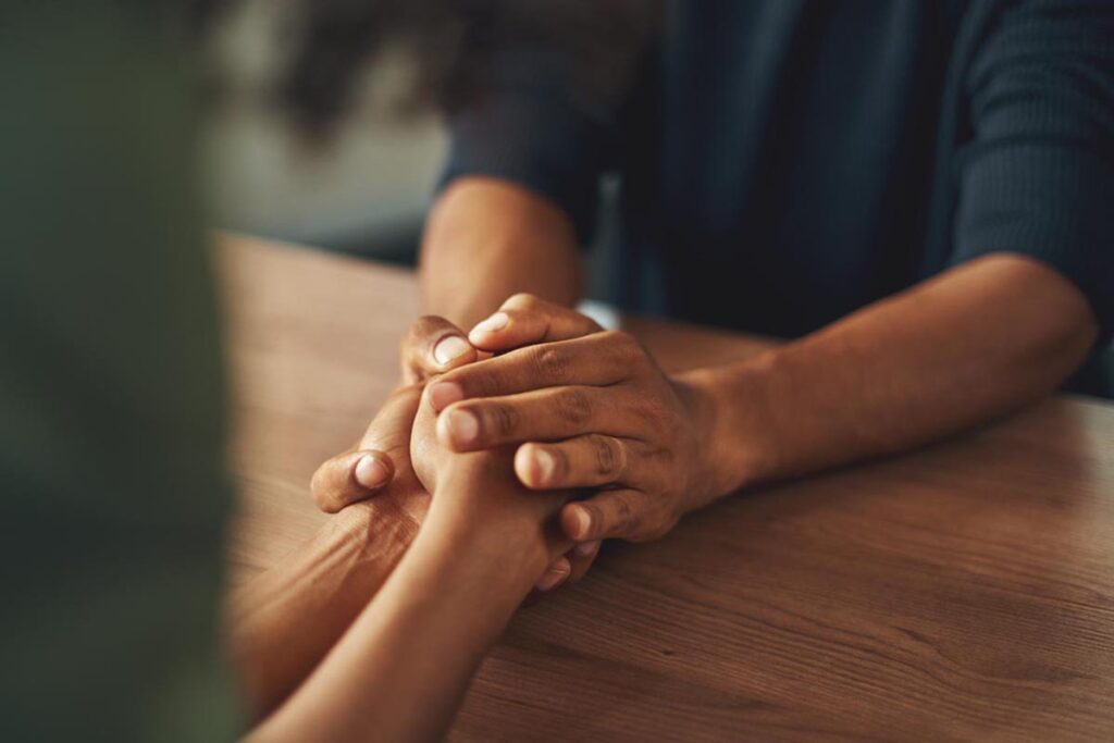 therapist holding client's hands discussing counseling vs therapy