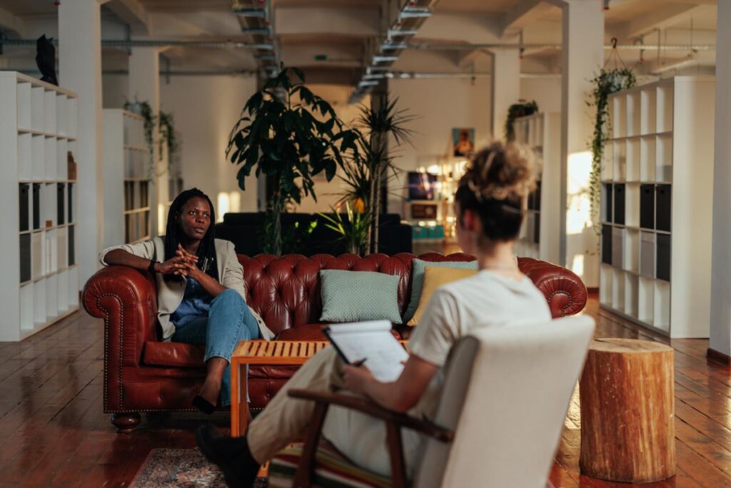 therapist and client on couch discuss trauma-informed care