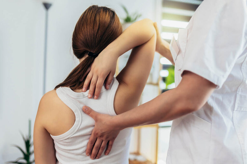 woman explains to therapist where the pain is as she learns what pain management treatment is