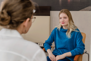woman in blue sweater talks with therapist in an anxiety treatment program