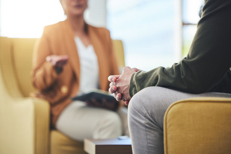 therapist talking with client in office setting as part of a cognitive-behavioral therapy program